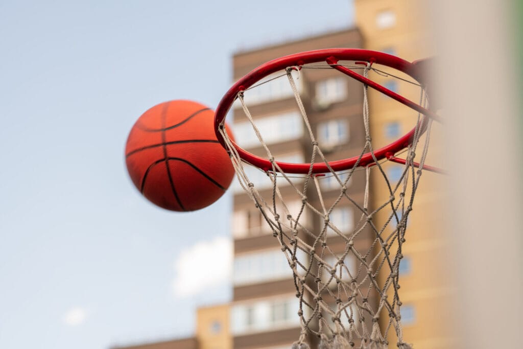 basketball thrown by player close to basket 