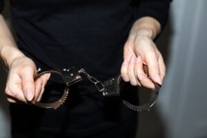 Melissa Hague | What Happens If the Person Who Assaulted Me Was Never Arrested? steel handcuffs of police special equipment, fetters on a black background