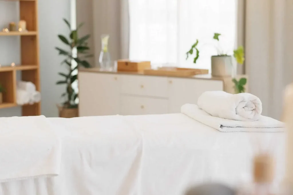 Massage therapy room with a massage table, towels, and calming ambiance.