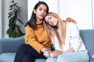Supportive women comforting each other during a difficult time.